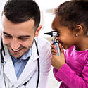 Little girl examining a medical professional in a playful manner